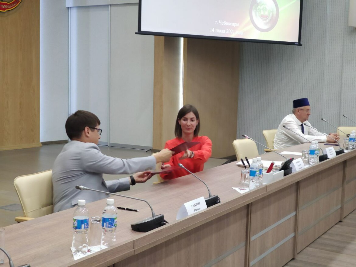 Шамиль Садыков и Кристина Майнина обмениваются копиями соглашения.